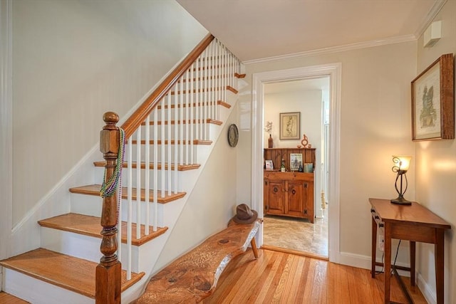stairs featuring baseboards, ornamental molding, and wood finished floors