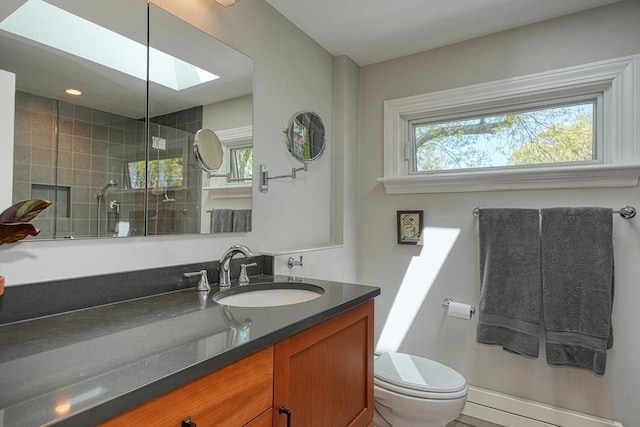 full bathroom with a skylight, vanity, a shower stall, and toilet