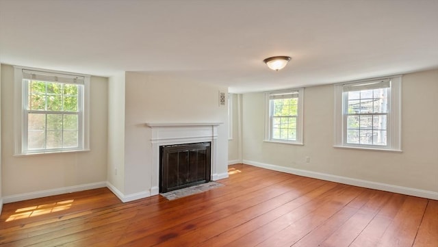 141 State St Unit 2, Newburyport, MA 01950 - unfurnished living room featuring hardwood / wood-style floors, a fireplace with flush hearth, and baseboards