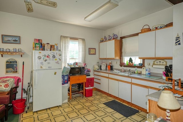 7 Prospect St, Woburn, MA 01801 - kitchen with freestanding refrigerator, light countertops, light floors, black microwave, and white cabinetry
