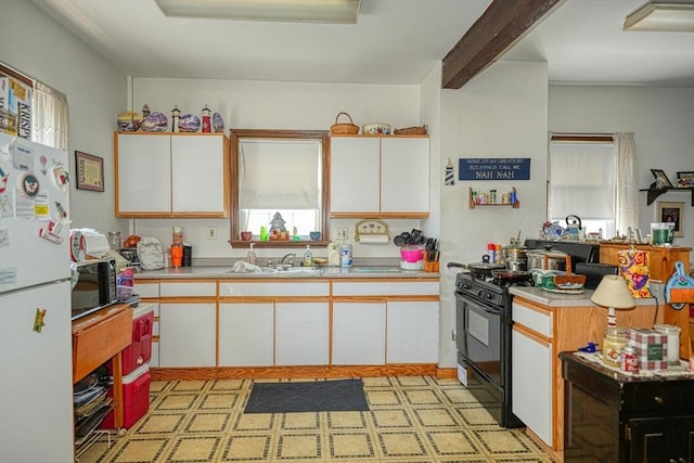 7 Prospect St, Woburn, MA 01801 - kitchen with black appliances, a sink, light countertops, white cabinets, and light floors