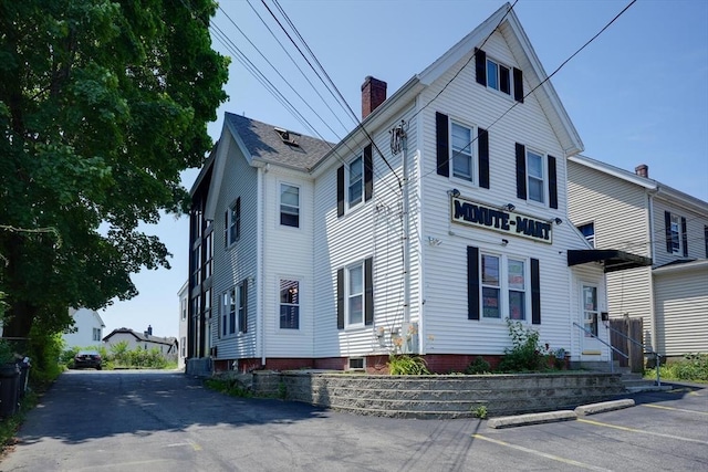 7 Prospect St, Woburn, MA 01801 - view of side of property featuring a chimney and uncovered parking