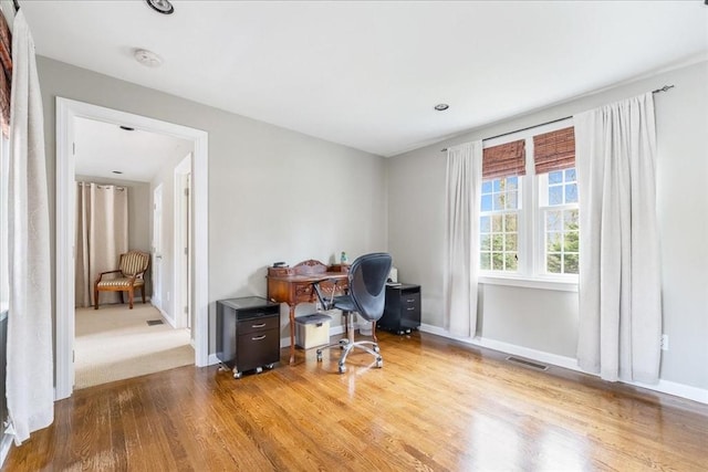office space with baseboards, wood finished floors, and visible vents