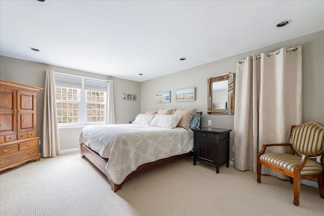 bedroom with baseboards and light carpet