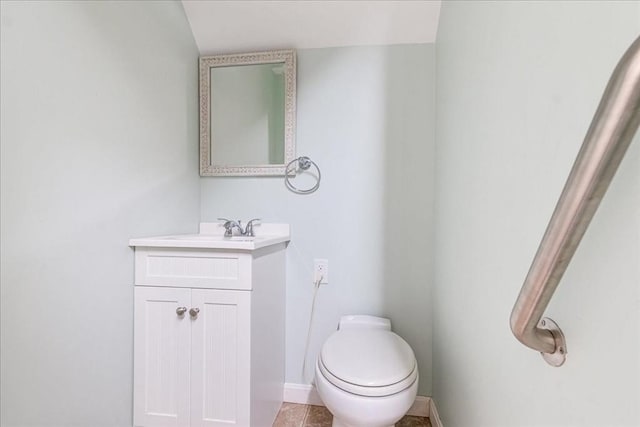 half bathroom featuring toilet, baseboards, tile patterned floors, and vanity