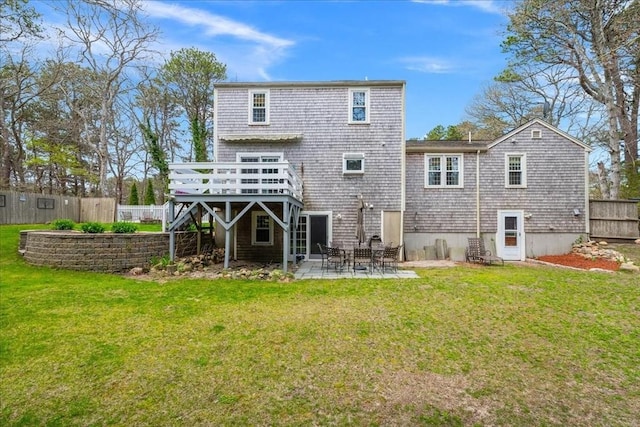 rear view of house with a lawn, a patio area, fence, and a deck