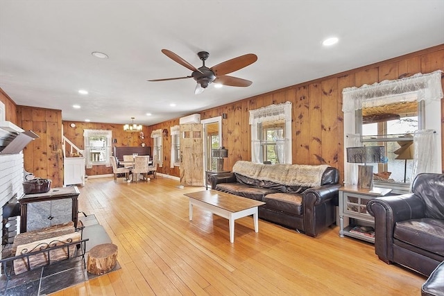 living area featuring wood walls, ceiling fan, light wood-style floors, a wall unit AC, and recessed lighting