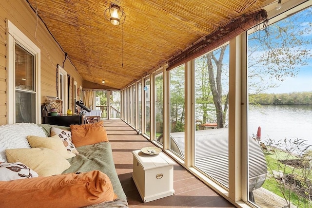 sunroom with a water view and vaulted ceiling