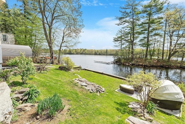 view of green lawn featuring a water view