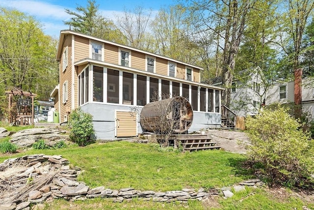 back of property featuring a sunroom and a yard
