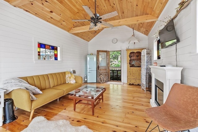 living room with wood ceiling, wood-type flooring, wooden walls, a ceiling fan, and a glass covered fireplace