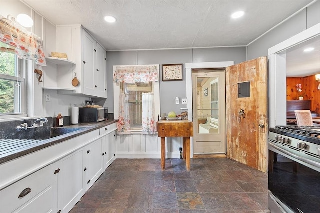 kitchen featuring stainless steel appliances, open shelves, dark countertops, white cabinets, and recessed lighting