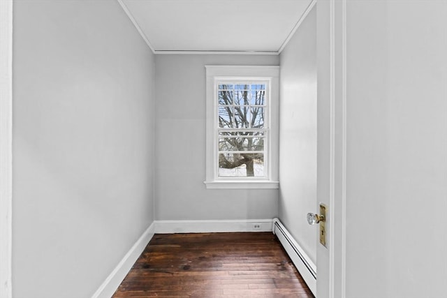 unfurnished room featuring dark hardwood / wood-style flooring, crown molding, and baseboard heating