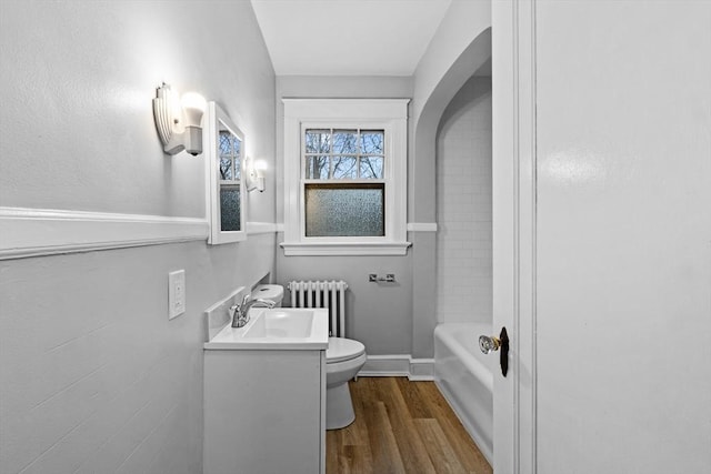 bathroom featuring radiator heating unit, toilet, hardwood / wood-style floors, and vanity