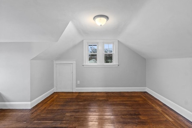 bonus room with dark hardwood / wood-style flooring and vaulted ceiling