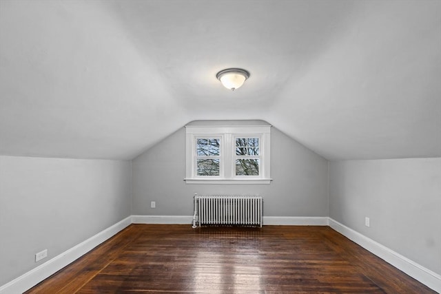 bonus room featuring lofted ceiling, radiator heating unit, and dark hardwood / wood-style flooring