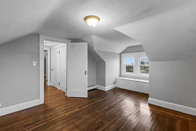 additional living space with a baseboard radiator, lofted ceiling, and dark hardwood / wood-style floors