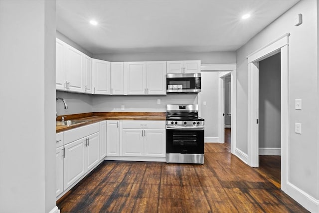 kitchen featuring sink, dark hardwood / wood-style floors, white cabinets, and appliances with stainless steel finishes