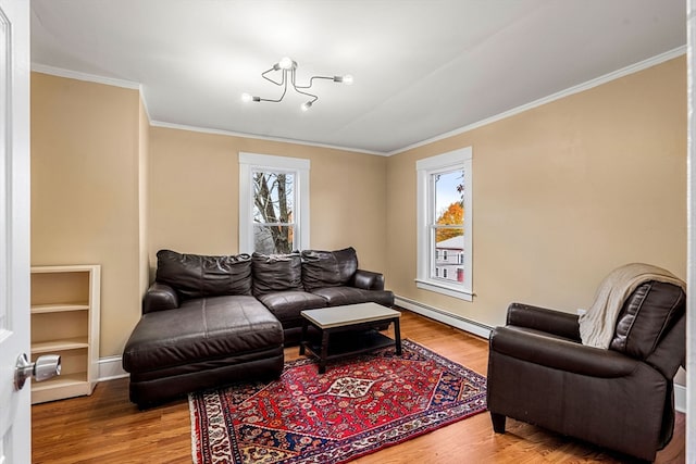 living room with wood-type flooring, ornamental molding, and a baseboard heating unit