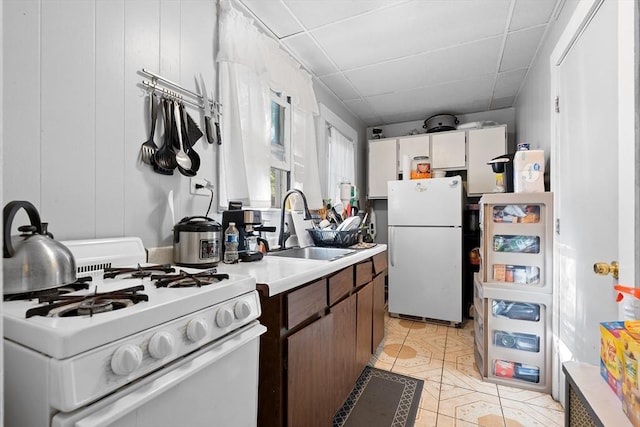 73 Lincoln Ave, Saugus, MA 01906 - kitchen featuring white appliances, a sink, light countertops, light tile patterned floors, and a paneled ceiling