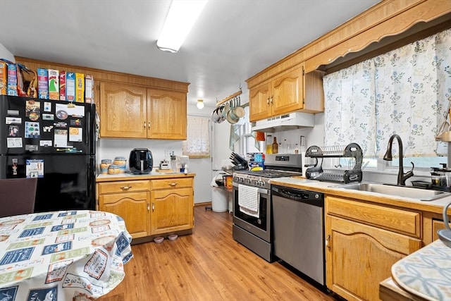 73 Lincoln Ave, Saugus, MA 01906 - kitchen featuring appliances with stainless steel finishes, a sink, light countertops, light wood-style flooring, and under cabinet range hood