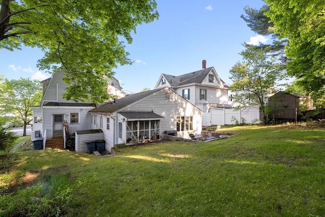 73 Lincoln Ave, Saugus, MA 01906 - back of property with a sunroom, a chimney, and a yard