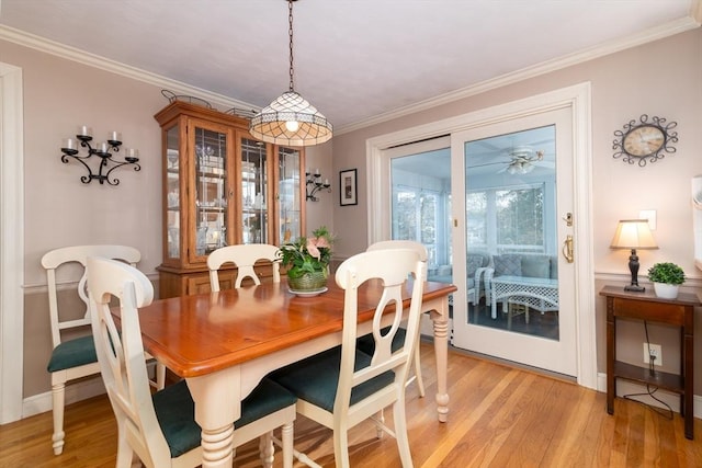 dining space featuring crown molding and light wood-style floors