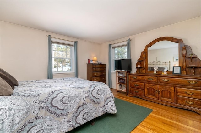 bedroom with multiple windows and wood finished floors