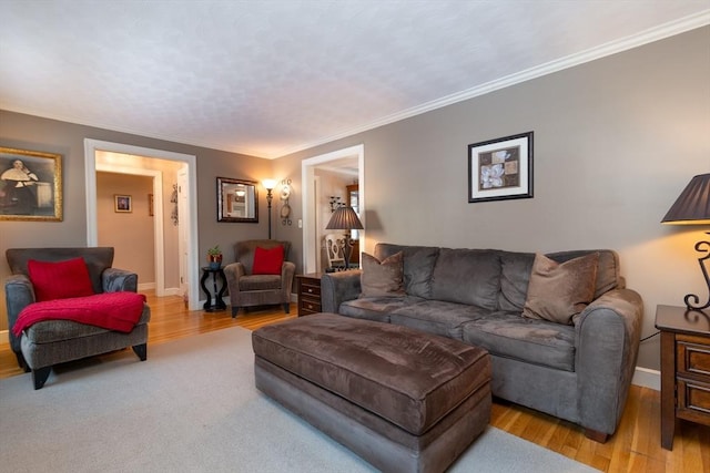 living room featuring light wood-style floors, baseboards, and ornamental molding