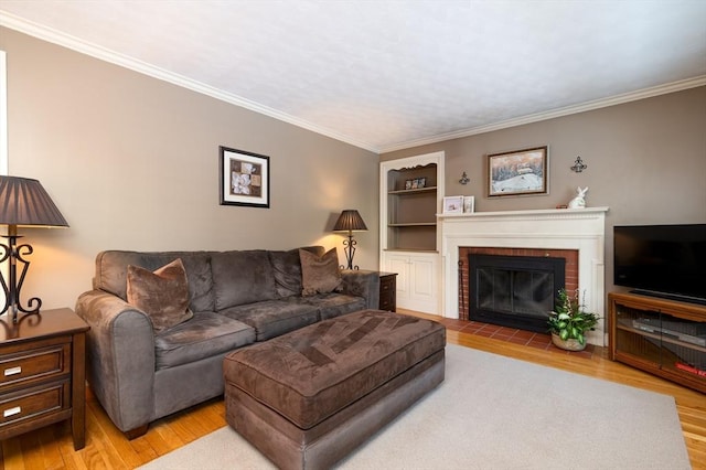 living room with crown molding, a fireplace, built in features, and wood finished floors