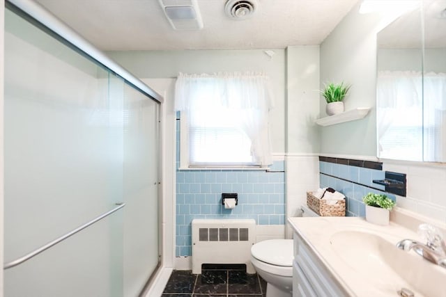 33 Page Rd, North Attleboro, MA 02760 - bathroom with radiator heating unit, a stall shower, vanity, tile walls, and wainscoting