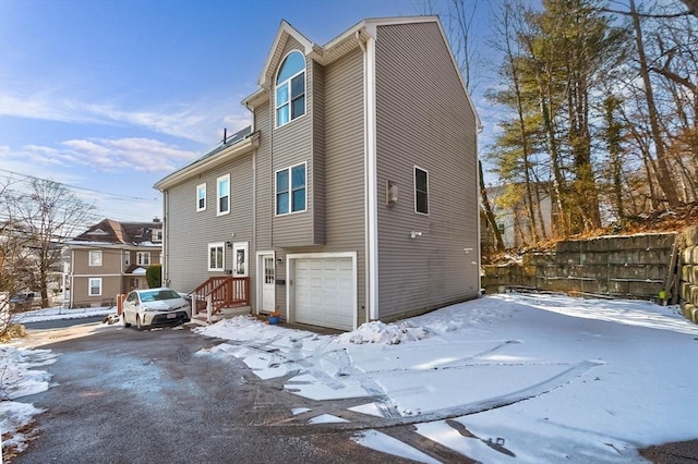 view of snowy exterior with a garage