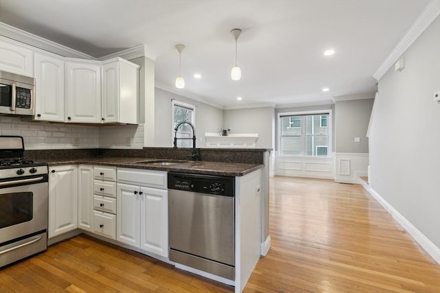 kitchen with stainless steel appliances, sink, and white cabinets