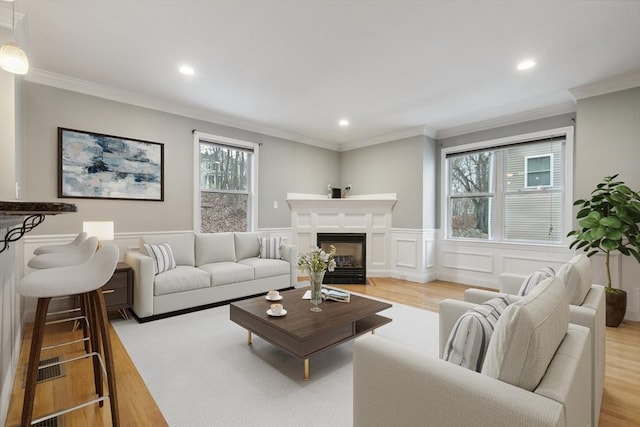 living room featuring light hardwood / wood-style flooring and ornamental molding