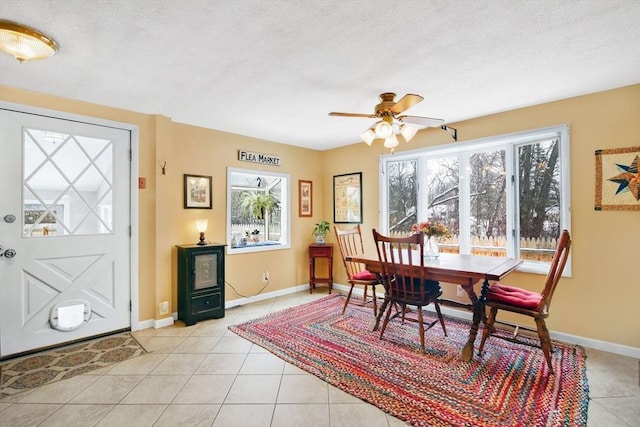 tiled dining space featuring ceiling fan and a textured ceiling