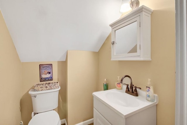 bathroom with vanity, vaulted ceiling, and toilet