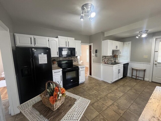 kitchen featuring black appliances, light countertops, white cabinets, tasteful backsplash, and a sink