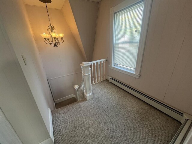 staircase featuring baseboard heating, carpet, and a chandelier