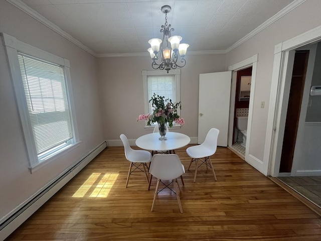 dining space with a baseboard radiator, a chandelier, wood-type flooring, crown molding, and baseboards