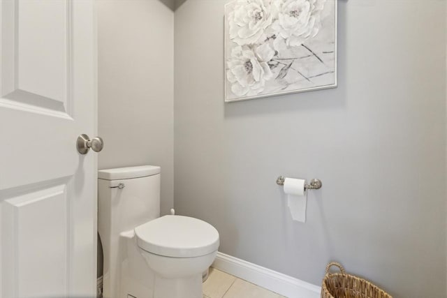 bathroom featuring baseboards, tile patterned floors, and toilet