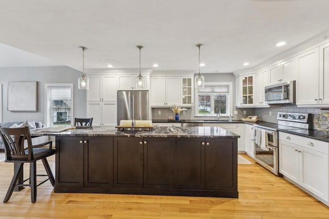 kitchen featuring white cabinets, appliances with stainless steel finishes, and a center island