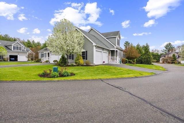 traditional-style house with an attached garage, a front lawn, and aphalt driveway
