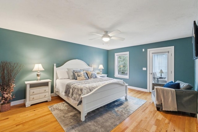 bedroom featuring baseboards, access to exterior, and light wood-style flooring