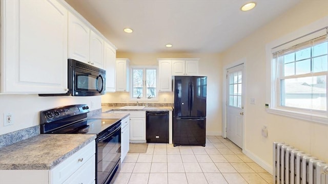 kitchen with light tile patterned floors, radiator heating unit, recessed lighting, black appliances, and white cabinetry