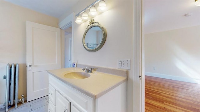 bathroom featuring tile patterned floors, vanity, radiator heating unit, and baseboards