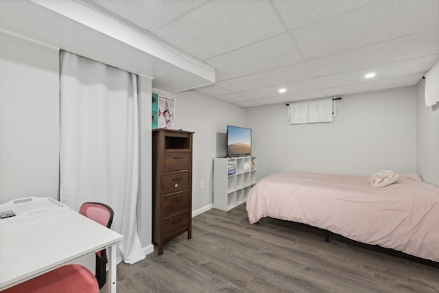 bedroom featuring hardwood / wood-style flooring and a drop ceiling