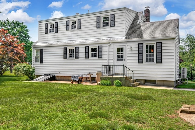 rear view of property with a lawn