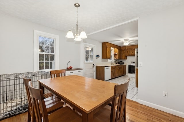 dining space featuring sink, light hardwood / wood-style flooring, and a healthy amount of sunlight