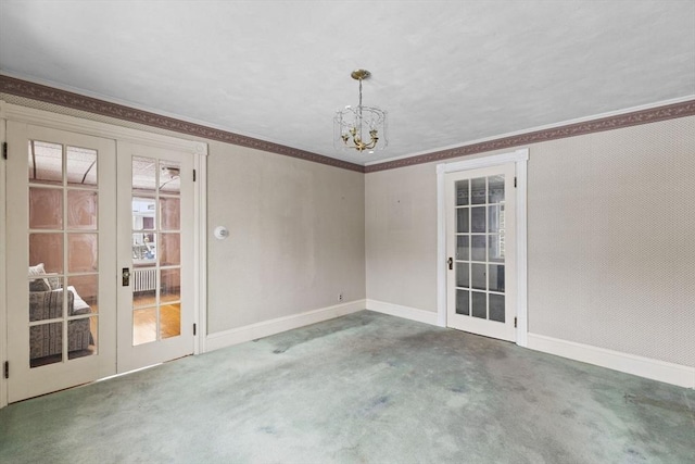 carpeted spare room featuring a chandelier, crown molding, and french doors