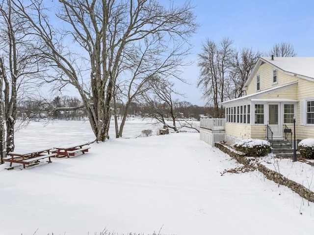 snowy yard with a sunroom